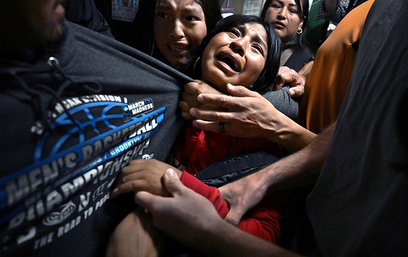 Separated by ICE by Carol Guzy _© Carol Guzy, ZUMA Press, iWitness, for Miami Herald Title: ICE Arrests at New York CourtCredit: © Carol Guzy, ZUMA Press, iWitness, for Miami HeraldCaption: ​​“Please understand we are coming here for a better opportunity, not just for ourselves, but for our children,” said Cocha, after her husband, Luis, was detained by ICE agents following an immigration court hearing at the Jacob K. Javits Federal Building. Luis, an Ecuadorian migrant whom his family says has no criminal record, served as the household’s sole provider. This photograph, taken inside one of the few US federal buildings where photographers were granted access, captures a harrowing moment: a family separated by the state. What Carol Guzy has documented is not an isolated instance, but a policy indiscriminately applied to people who arrive for hearings in good faith. Cocha and their three children – ages seven, 13, and 15 – were left inconsolable, facing immediate financial hardship and profound emotional trauma. In a democracy, the camera’s presence in that hallway is an essential witness to a policy that has turned courthouses into sites of shattered lives.Story: In 2025, shifts in US immigration policy transformed courthouses into focal points for mass deportation efforts by US Immigration and Customs Enforcement (ICE). Masked ICE agents detained undocumented migrants immediately following their hearings, often leading to deeply traumatic family separations. These aggressive tactics, coupled with severely overcrowded and unsanitary conditions at the 10th-floor holding facility in the Jacob K. Javits Federal Building in New York, prompted fierce public protests, class-action lawsuits, and the arrest of local elected officials demanding accountability.